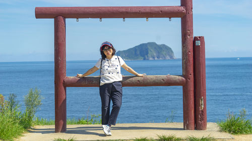 Portrait of young woman standing at beach