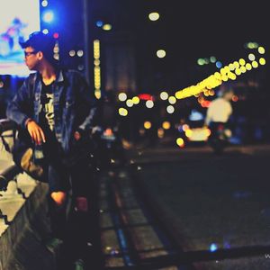 Man standing in illuminated city at night