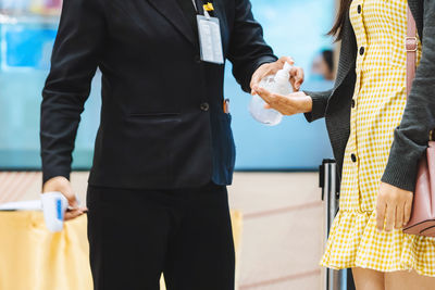 Midsection of man holding ice cream standing outdoors