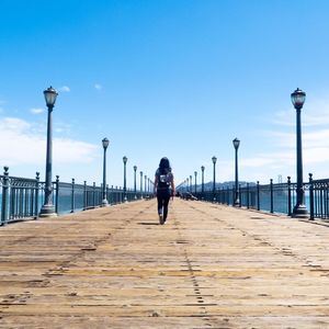 Rear view of man walking on walkway