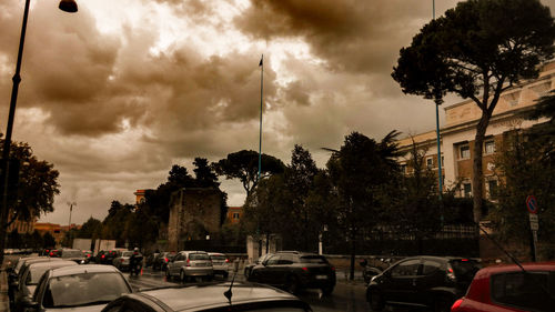 Cars on road against sky in city