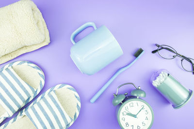 High angle view of personal accessories on purple background