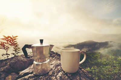 Coffee cup on table against sky