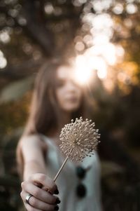 Woman holding dandelion flower