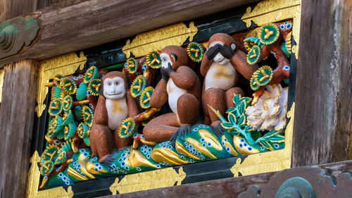 Low angle view of statues on wood outside temple