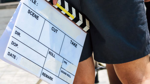 Midsection of woman with film slate