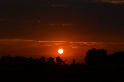 Scenic view of silhouette trees against romantic sky at sunset