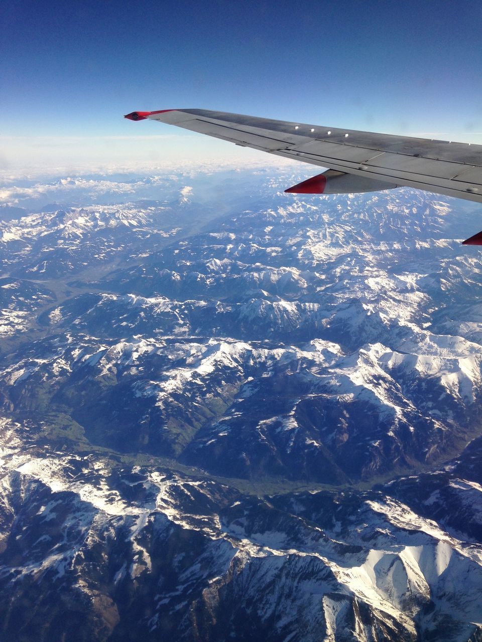 AERIAL VIEW OF AIRPLANE FLYING ABOVE SNOWCAPPED MOUNTAIN