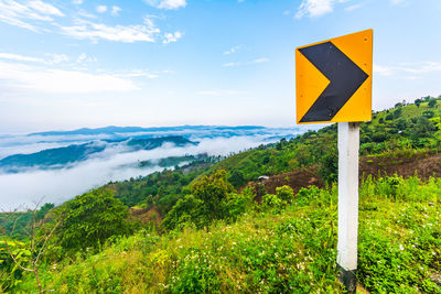 Road sign against sky