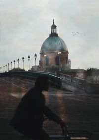 Silhouette of building against cloudy sky