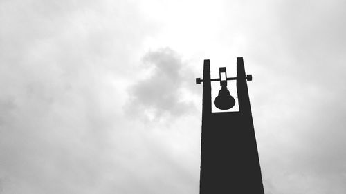 Low angle view of weather vane against sky