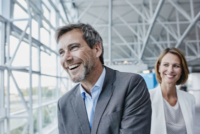 Happy businessman and businesswoman at the airport