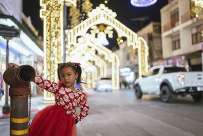 Portrait of young woman standing in city