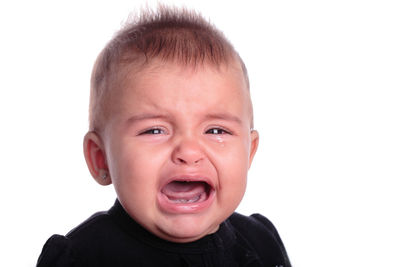 Close-up portrait of cute baby against white background