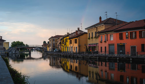 Canal amidst buildings against sky