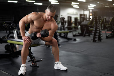 Full length of man exercising at gym