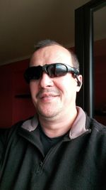 Portrait of mature man wearing sunglasses at home
