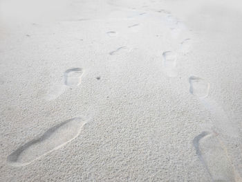 High angle view of footprints on sand at beach