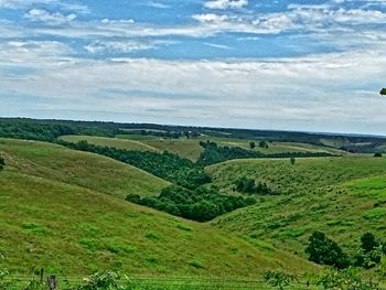 Scenic view of grassy field against sky