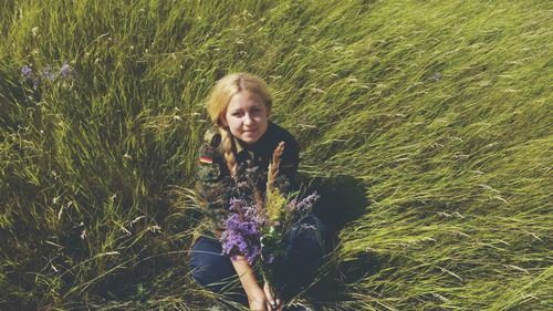 Portrait of smiling young woman sitting amidst plants
