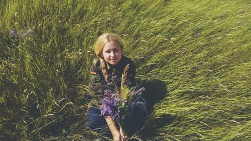 Portrait of young woman standing on field