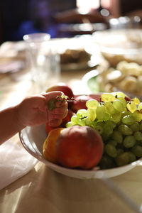 Hand reaching out for a fruits on table