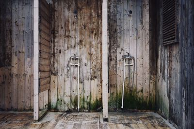 Old showers and faucets on wooden weathered wall