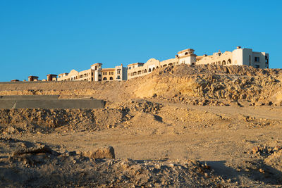 Scenic view of desert against clear blue sky