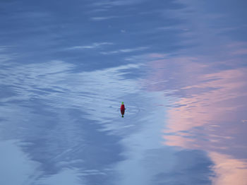 People in sea against sky