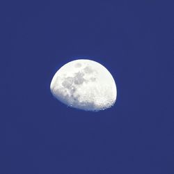 Low angle view of moon against blue sky