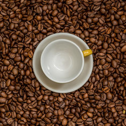 Close-up of roasted coffee beans with cups