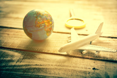 Close-up of airplane toy and globe on table