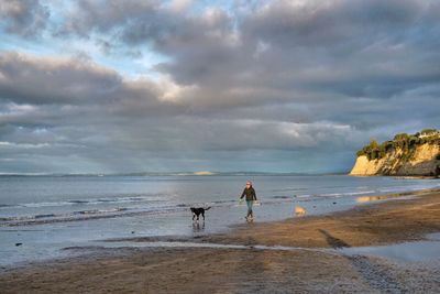 People walking on beach against sky