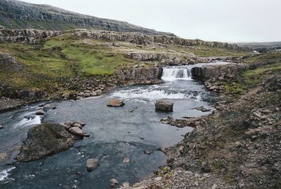 Scenic view of waterfall against sky