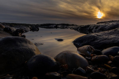 Scenic view of beach against dramatic sky