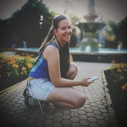 Portrait of a smiling young woman sitting outdoors