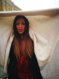 Portrait of beautiful woman standing against wall