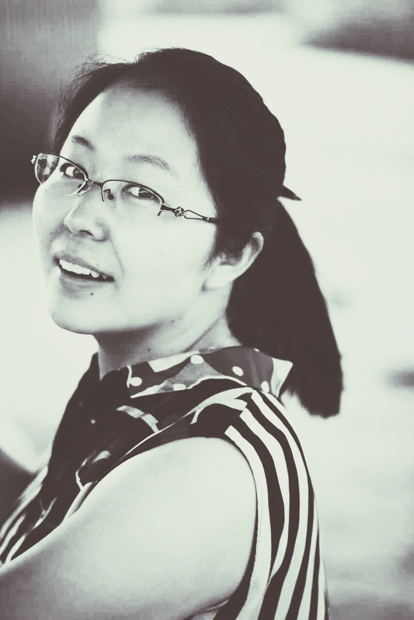 YOUNG WOMAN LOOKING AT CAMERA ON TABLE