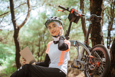 Smiling woman using digital tablet at park