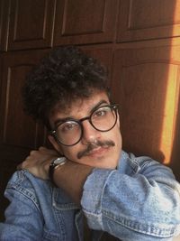 Portrait of young man wearing eyeglasses at home