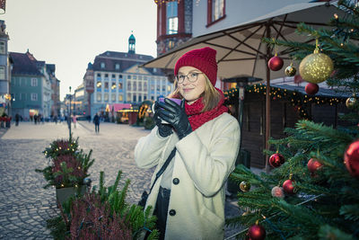 Portrait of smiling woman holding coffee cup standing outdoors