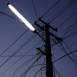 Low angle view of electricity pylon against clear sky