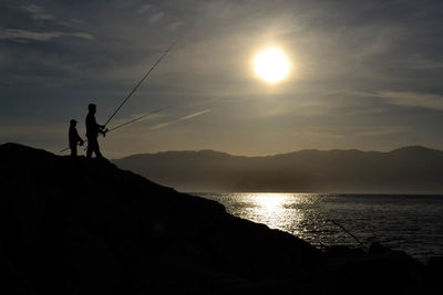 Silhouette of people at beach during sunset