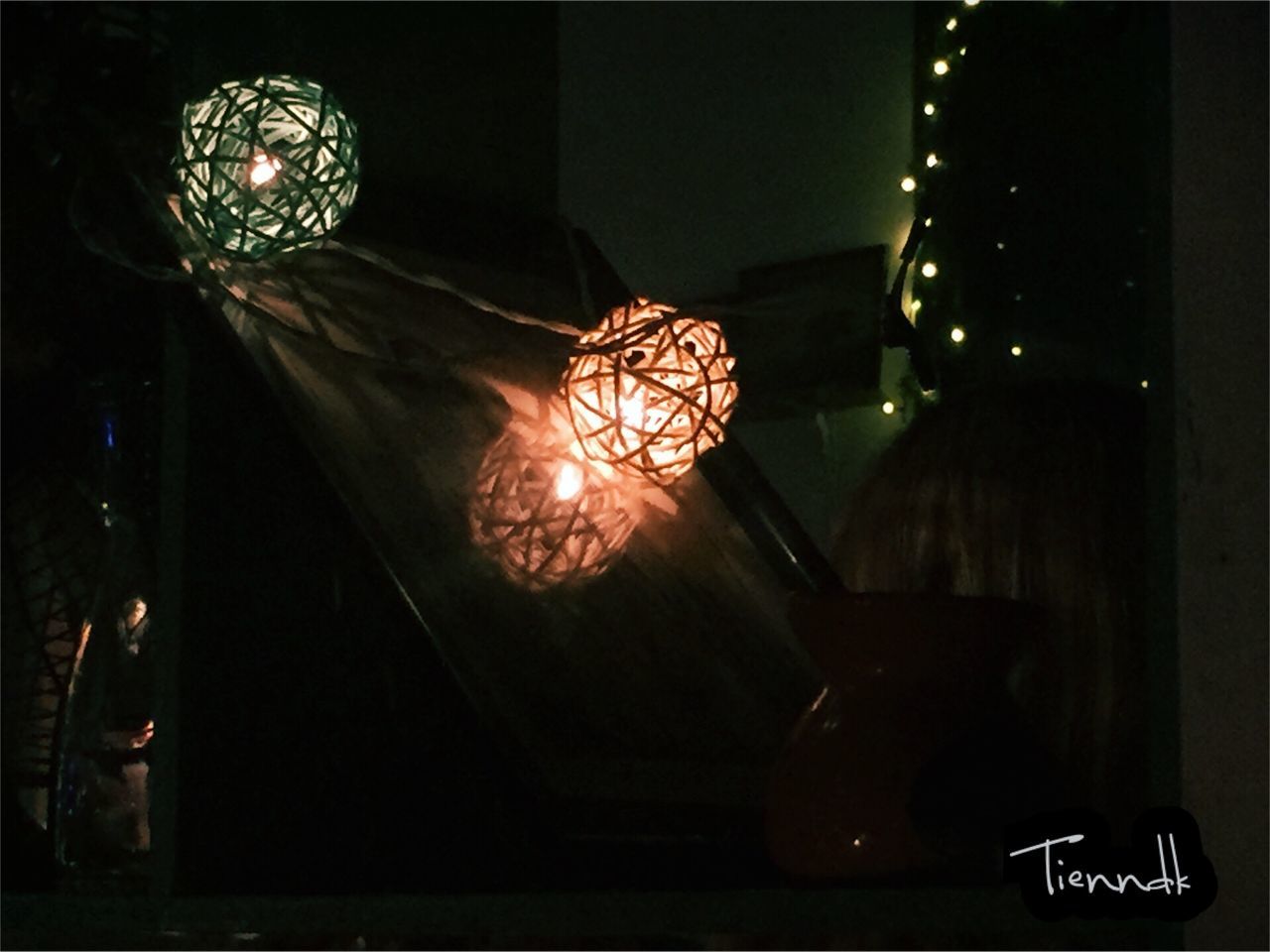 LOW ANGLE VIEW OF ILLUMINATED PENDANT LIGHTS HANGING FROM CEILING IN DARK