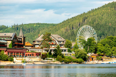 Buildings by lake against sky