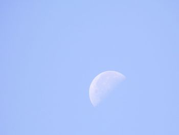 Low angle view of moon against clear blue sky