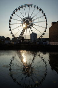 Ferris wheel against sky at sunset