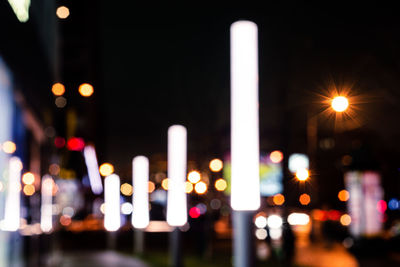 Defocused image of illuminated city against sky at night