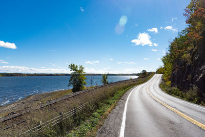 Empty road along calm lake