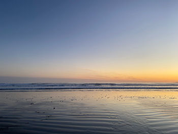 Scenic view of beach against sky during sunset